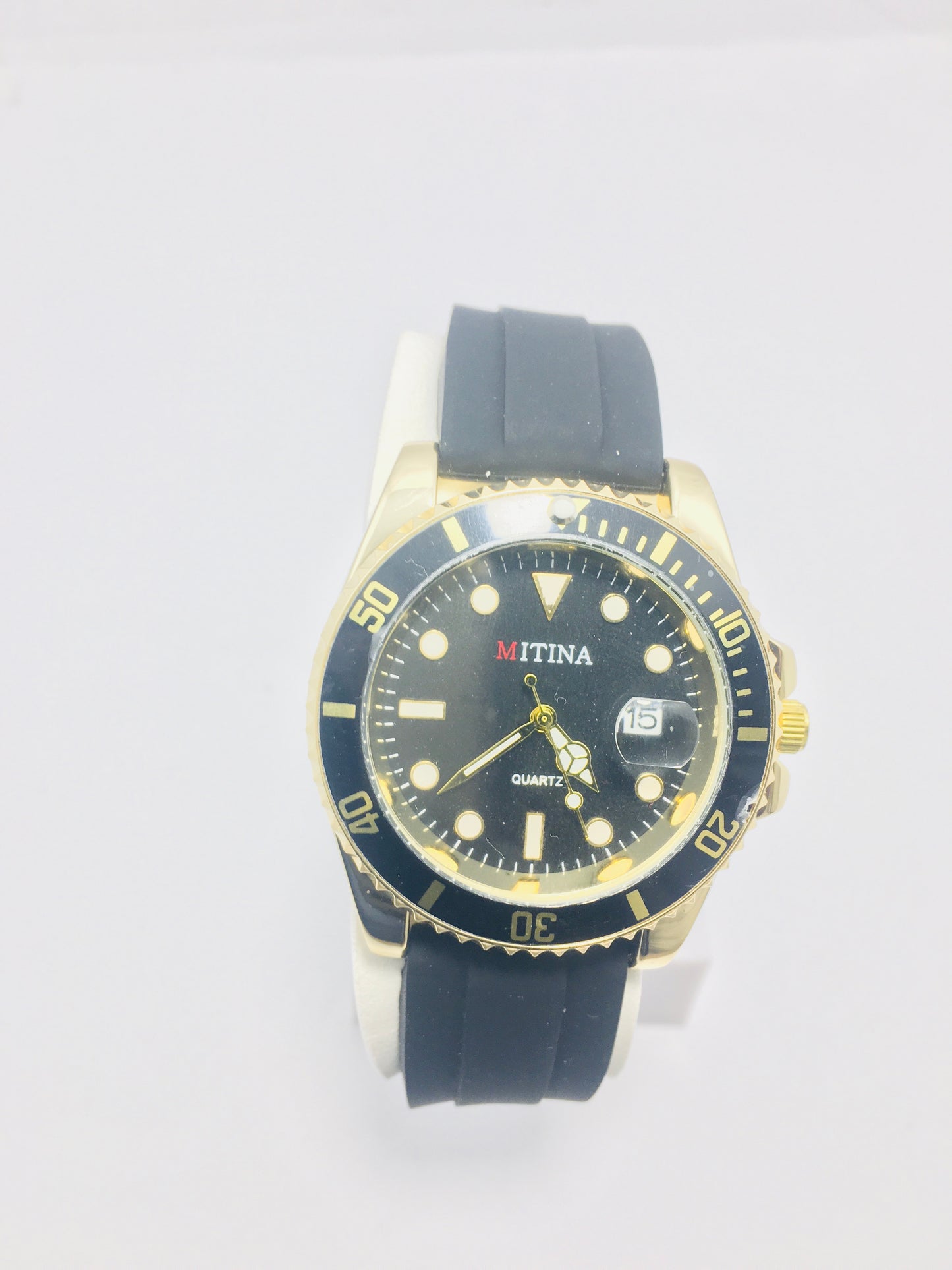 Mitina Movement diver-style watch with a black dial, gold-colored accents, a rotating bezel, and a date window. Rubber strap black